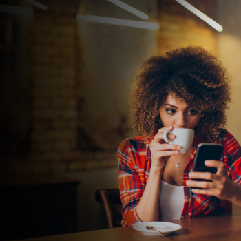 woman drinking a bru on phone